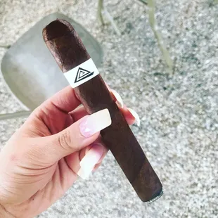 a hand holding a cigar