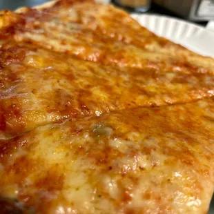 a slice of cheese pizza on a paper plate