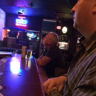 two men sitting at a bar