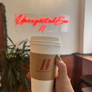a hand holding a cup of coffee