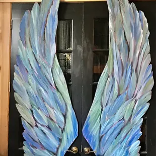 a pair of painted wings on a door