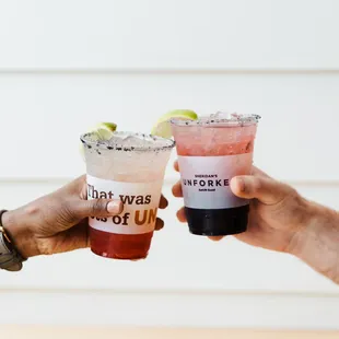 two people toasting with drinks