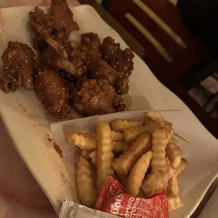 a plate of chicken wings and french fries