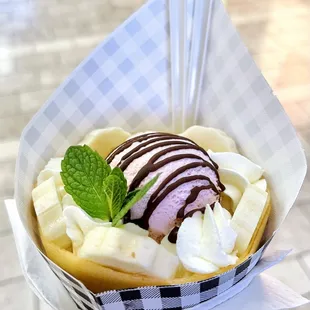 Banana, chocolate, whipped cream crepe with a scoop of strawberry ice cream