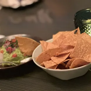 a bowl of chips and a bowl of guacamole