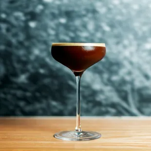 a glass of coffee on a wooden table