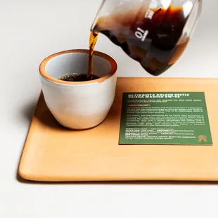 a person pouring coffee into a cup