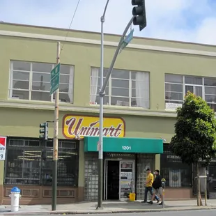 people walking on the sidewalk in front of a store