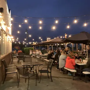 people sitting at tables under umbrellas