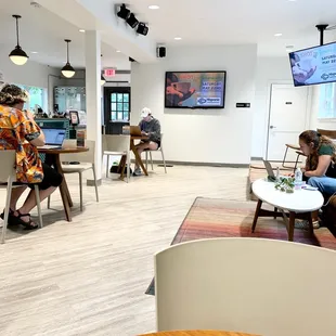 people sitting at tables and working on laptops