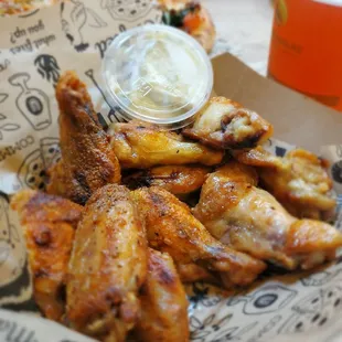 a basket of chicken wings and a glass of beer