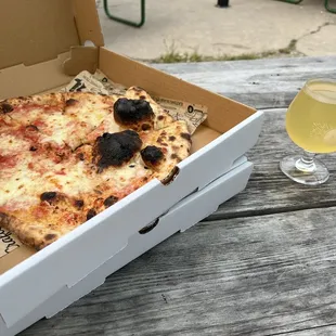 a box of pizza and a glass of beer
