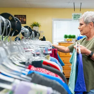 One of our Women's Clothes Closet volunteers restocking the rack