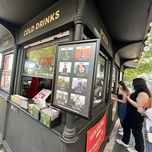 people standing outside of a cold drink shop