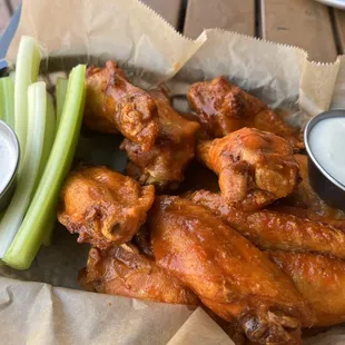 a basket of chicken wings and celery sticks