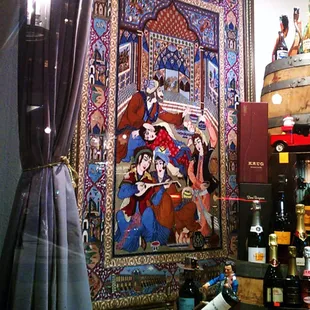 a tapestry and wine barrels