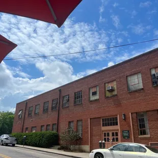 a white car parked in front of a brick building
