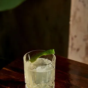 a glass of water with a lime garnish