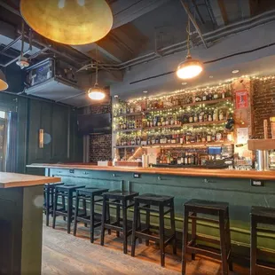 a bar with stools and lights