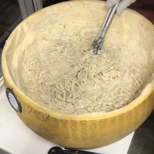 Fresh handmade fettuccine in parmiggiano reggiano wheel
