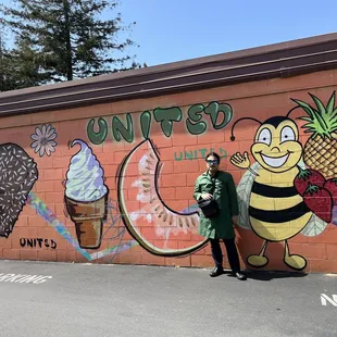 a man standing in front of a mural