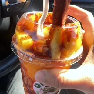 a person holding a cup of fruit