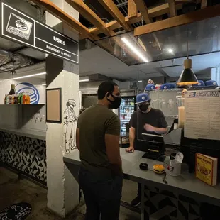 a man standing at a counter in a restaurant