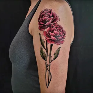 Experience the vibrancy of Christy Lumbergs' super colorful traditional style floral and flowers tattoo.