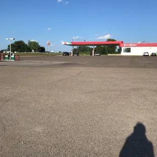 the shadow of a man in front of a gas station
