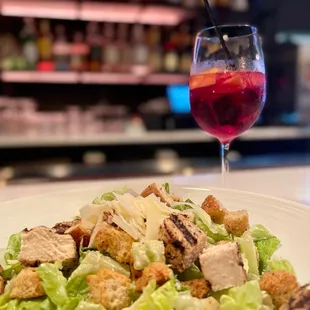 a plate of salad and a glass of wine