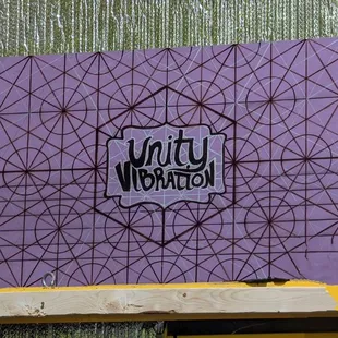 the logo on a purple wall