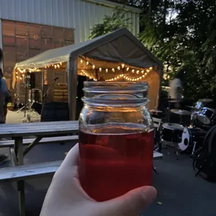 a person holding a jar of liquid
