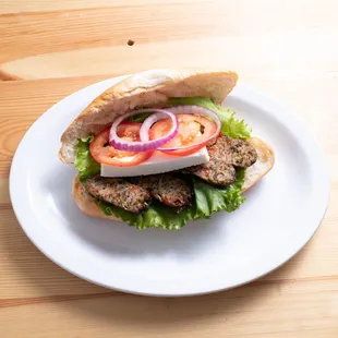 a sandwich with meat, lettuce, tomato, and onion