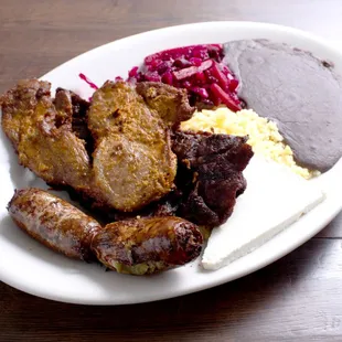 a plate of meat, rice, and beans