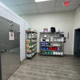 a refrigerator and shelves in a commercial kitchen