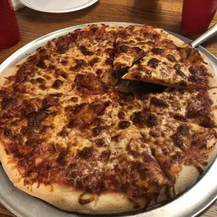 a pizza on a pan with a slice taken out of it