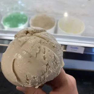 a hand holding a scoop of ice cream