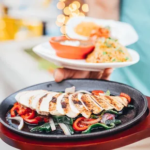 a person holding two plates of food