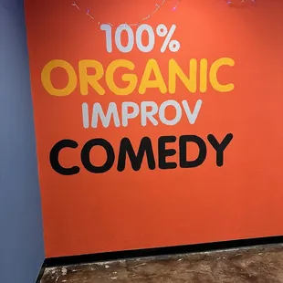 a sign that says 100 % organic improv comedy