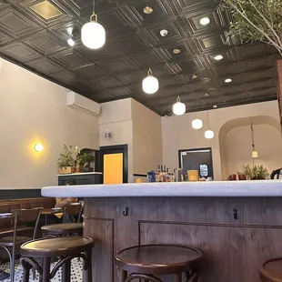 a bar with stools and tables
