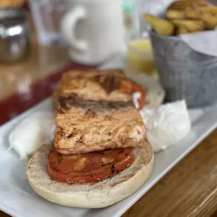 A very sad looking grilled salmon Benedict on top of a bagel - or rather a salmon fillet on top of some tomatoes