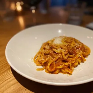 a plate of spaghetti with sauce and parmesan cheese
