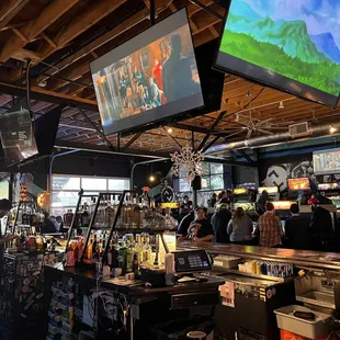 people in a sports bar watching tvs