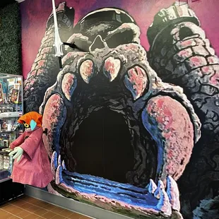 a woman in front of a mural