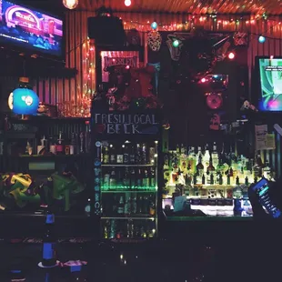 a bar with neon lights and a television
