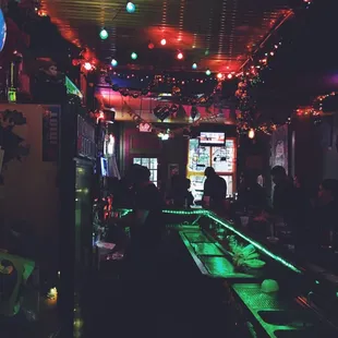 a dimly lit bar with neon lights