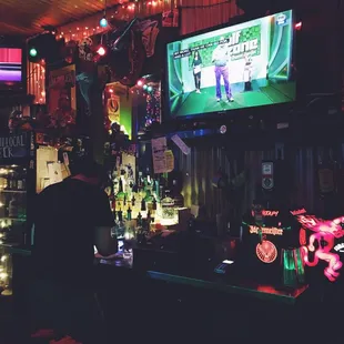 a man watching television in a bar