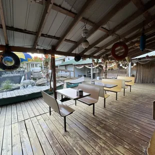 a wooden deck with tables and chairs