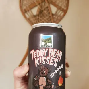 a hand holding a can of teddy bear kisses