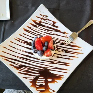 a plate of fruit with chocolate sauce